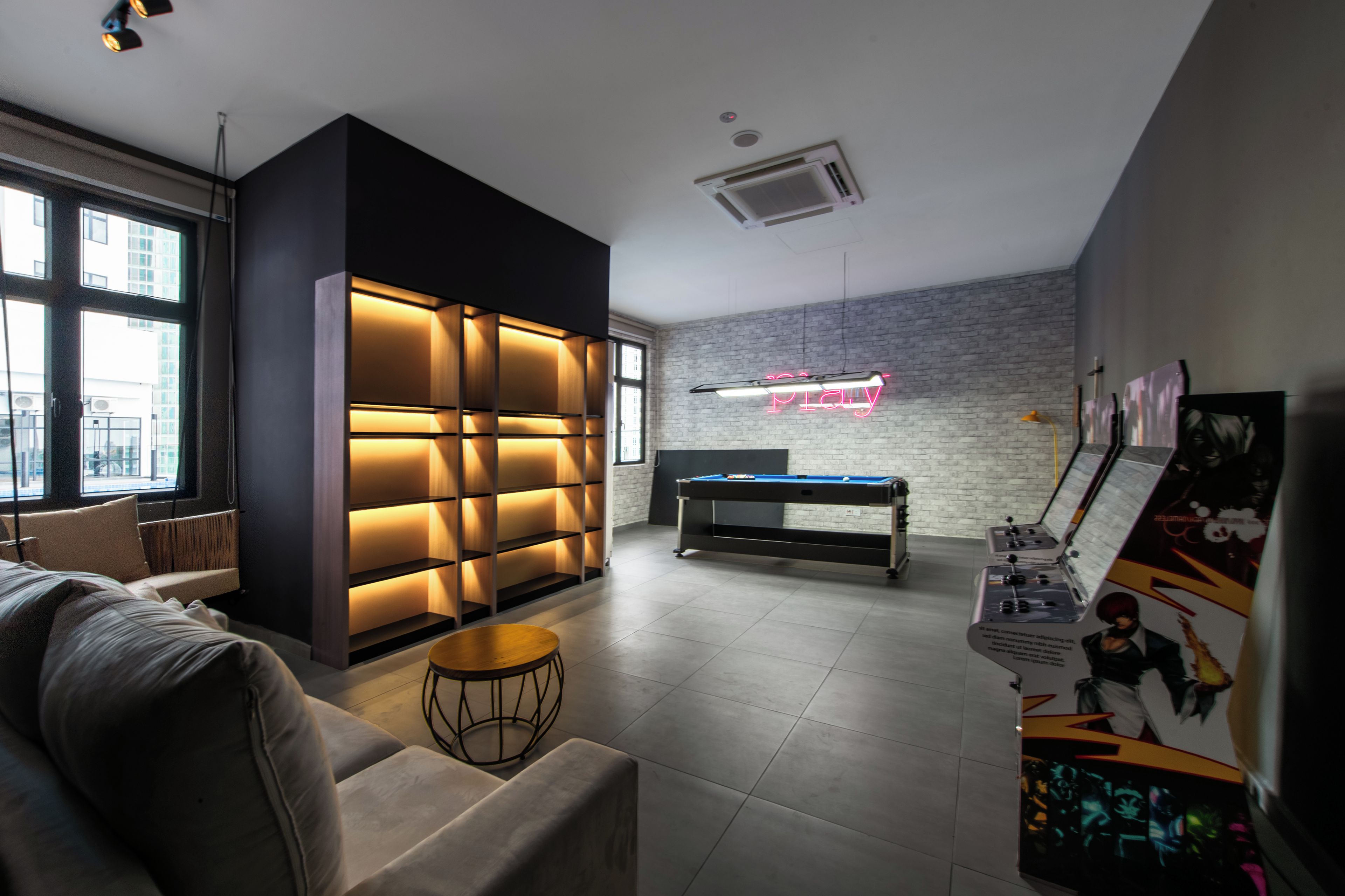 A modern room with a pool table, a neon sign, and a brick wall.