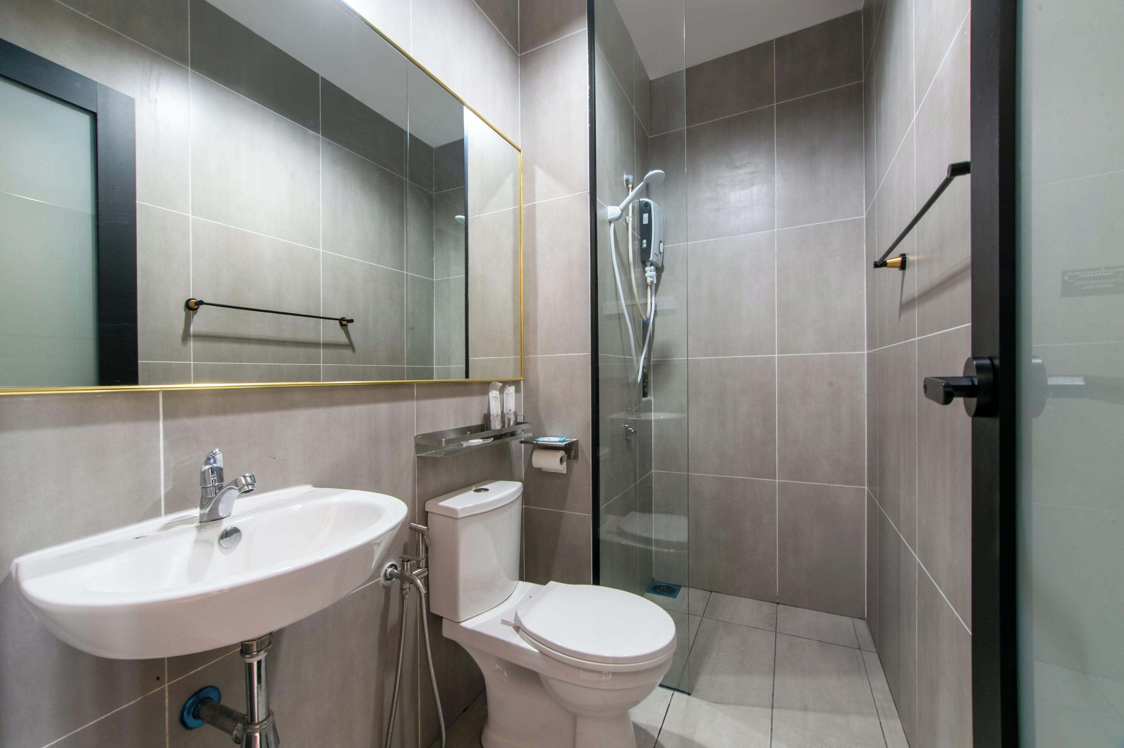 A modern bathroom with a sink, toilet, and glass-enclosed shower area.