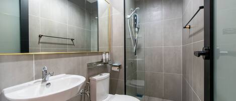 A modern bathroom with a sink, toilet, and glass-enclosed shower area.