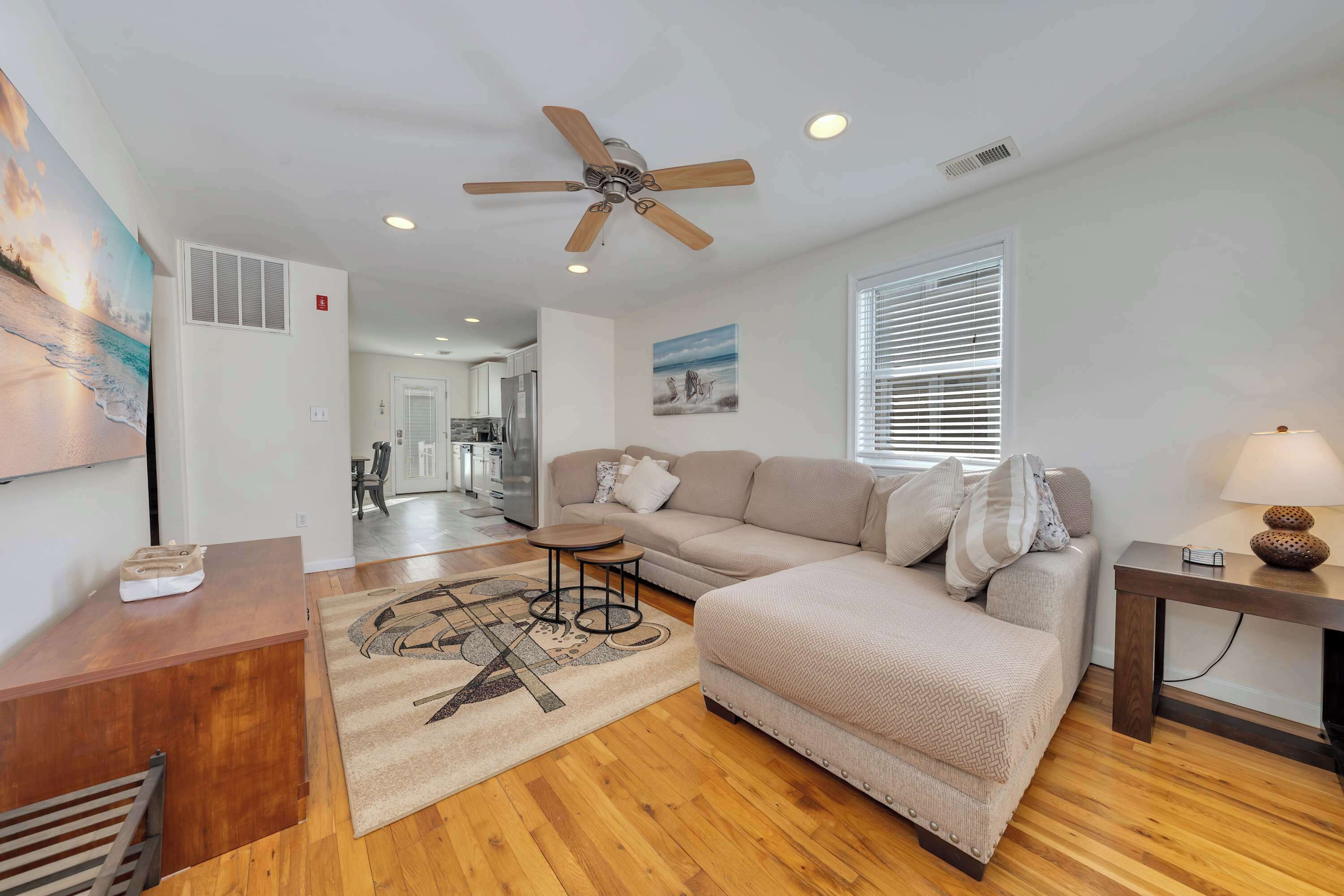 Un salon moderne avec un ventilateur de plafond, un canapé, une table basse et une lampe.