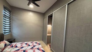 A bedroom with a bed, a ceiling fan, and a sliding door closet.