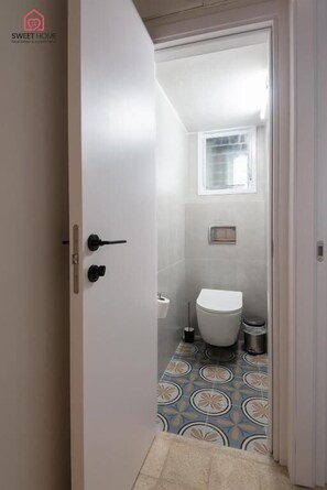 Ein Badezimmer mit Toilette, Bidet und kleinem Fenster.