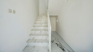 Un escalier avec des marches en marbre menant à un palier.