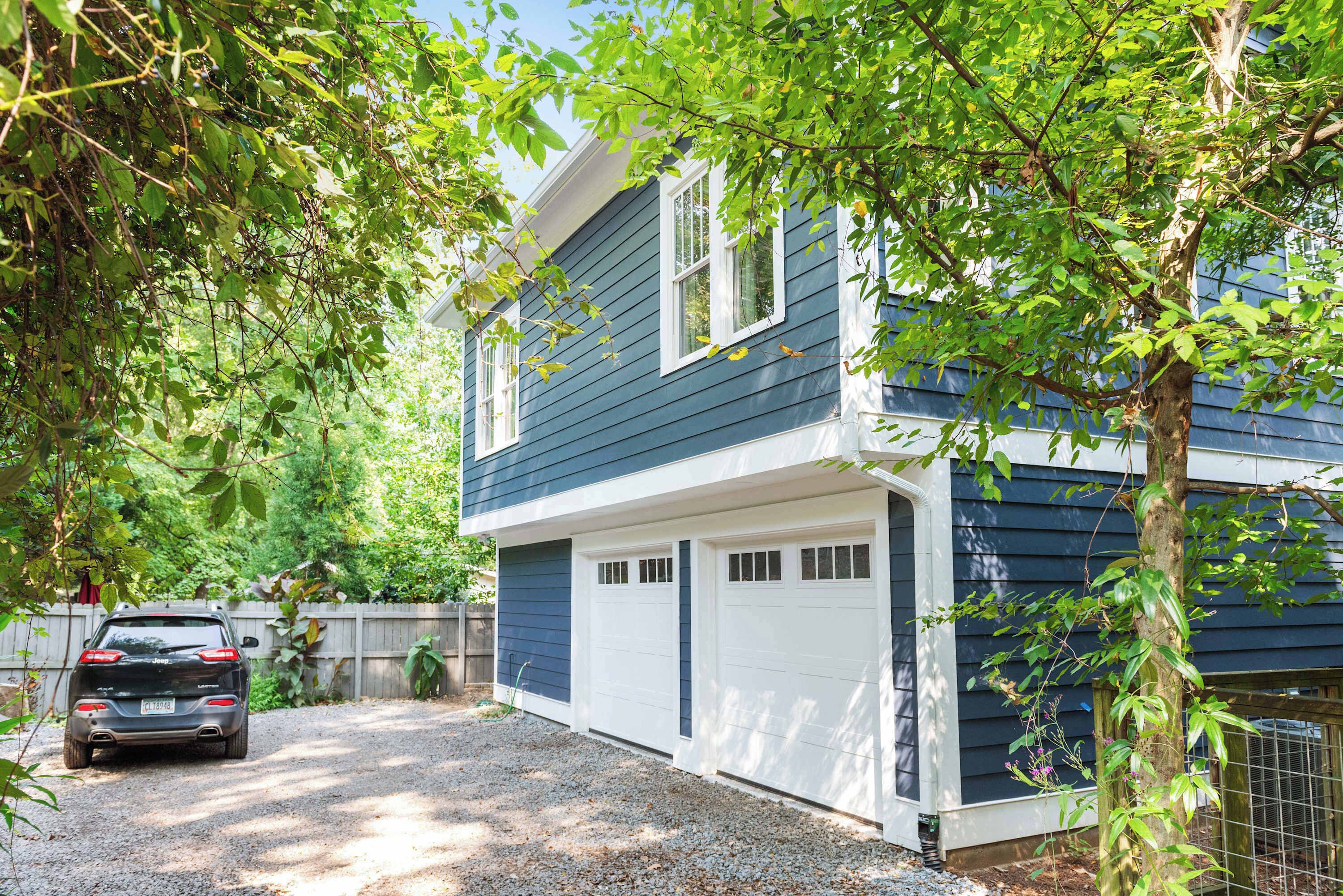A two-story house with a garage and a driveway.