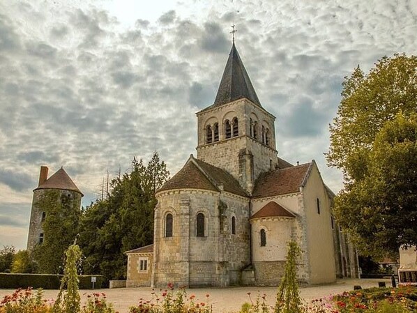 A historic church with a prominent tower, surrounded by trees and a well-maintained garden. - Charming renovated guest room with parking in La Berthenoux (La Berthenoux)