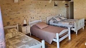 Un dormitorio con dos camas, una mesita de noche, una lámpara y techo de madera.