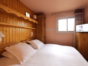 A wooden room with a bed, a TV, and a window. - Courchevel 1850 Center, 2-Room Apt, 4 People, Wifi, Balcony (Courchevel)