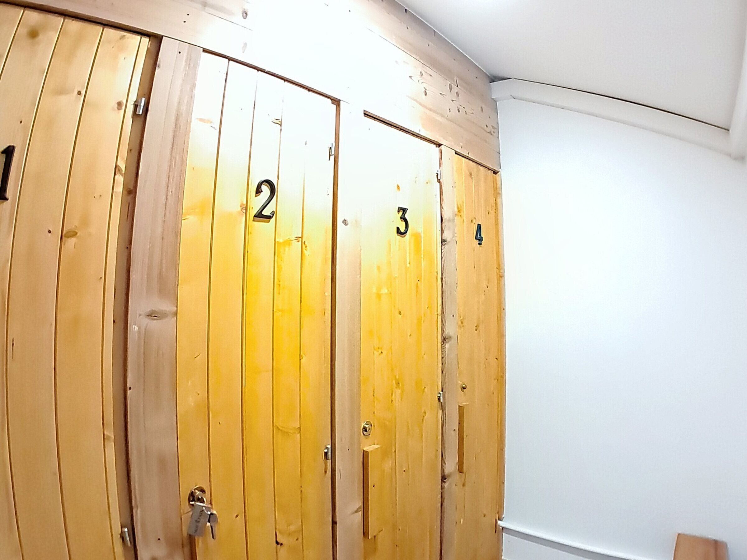 Un conjunto de taquillas de madera con los números del 1 al 4, probablemente para guardar objetos personales.