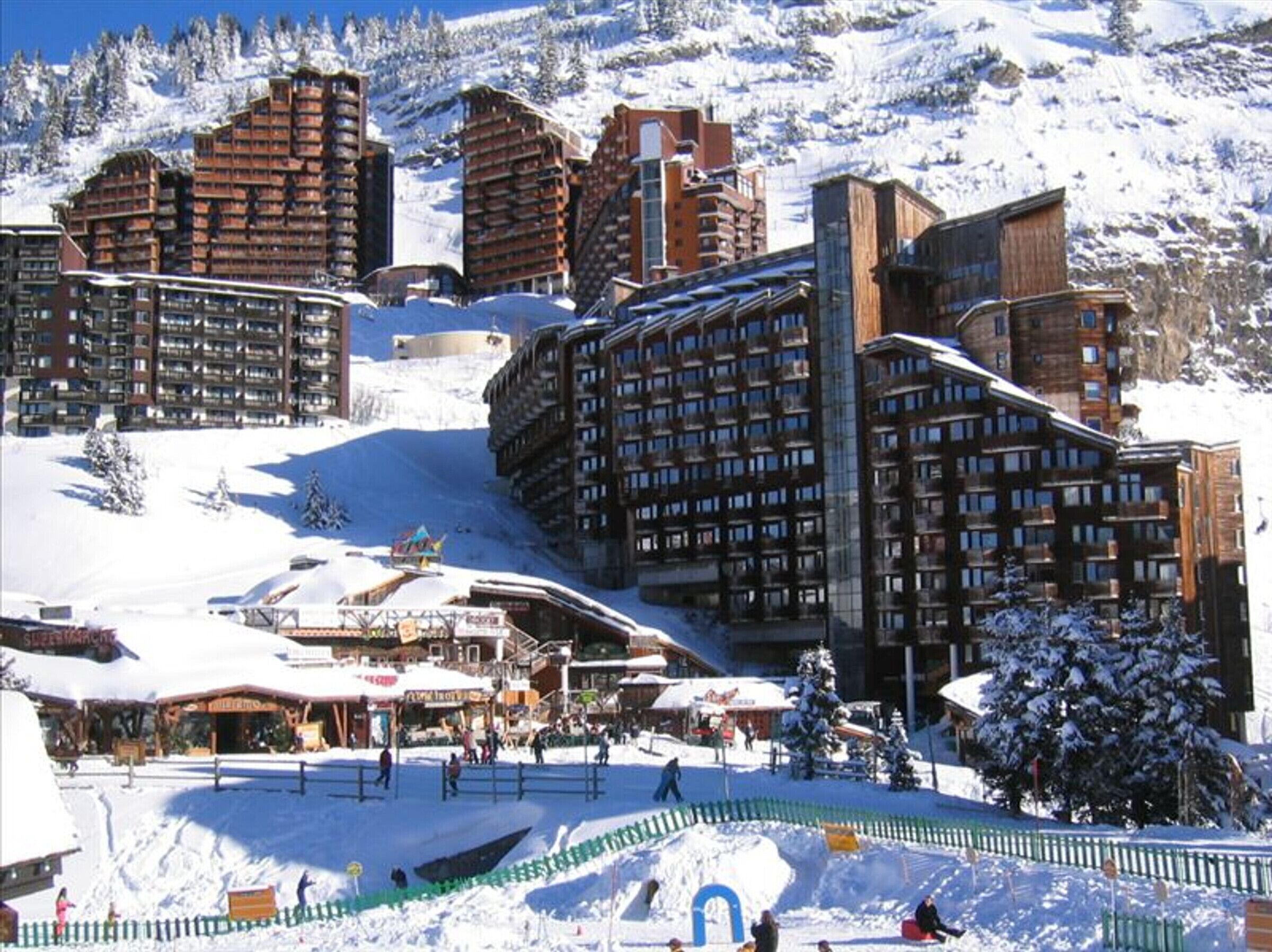 A ski resort with multiple high-rise buildings, ski slopes, and a snow-covered landscape.
