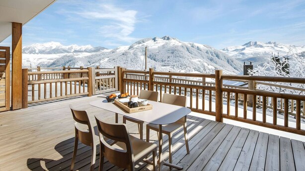 A wooden deck with a table and chairs, overlooking snow-covered mountains. - Comfortable T2 cabin for 6, ski shuttle, parking included (Les Saisies)