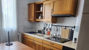 A modern kitchen with wooden cabinets, a countertop with a sink, and a dishwasher. - 70m2 apartment in Dijon, 4th floor without elevator, 5 minutes from Zenith (Dijon)