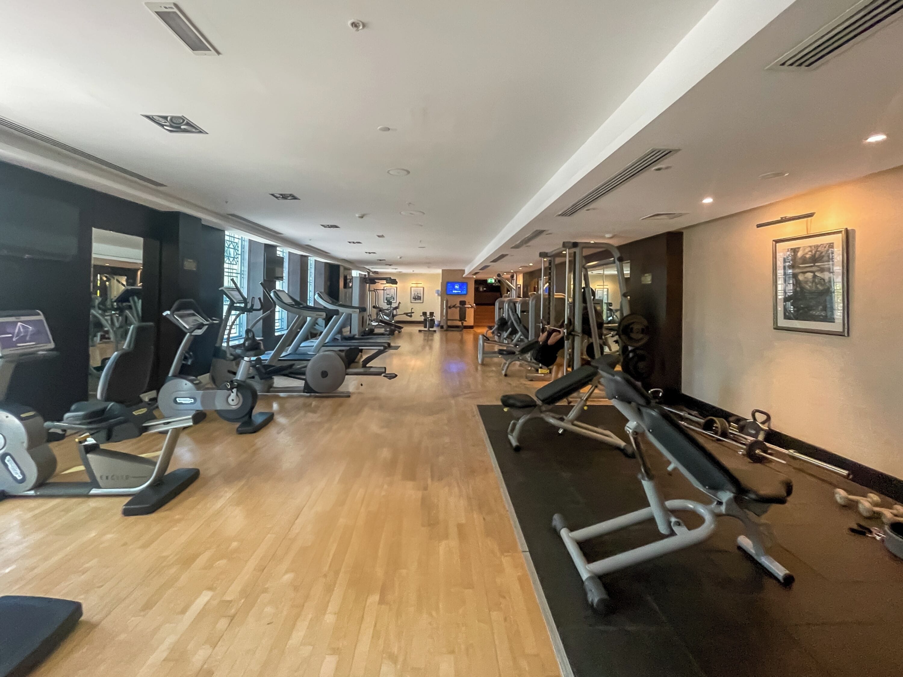 A gym with treadmills, elliptical machines, and weight equipment.