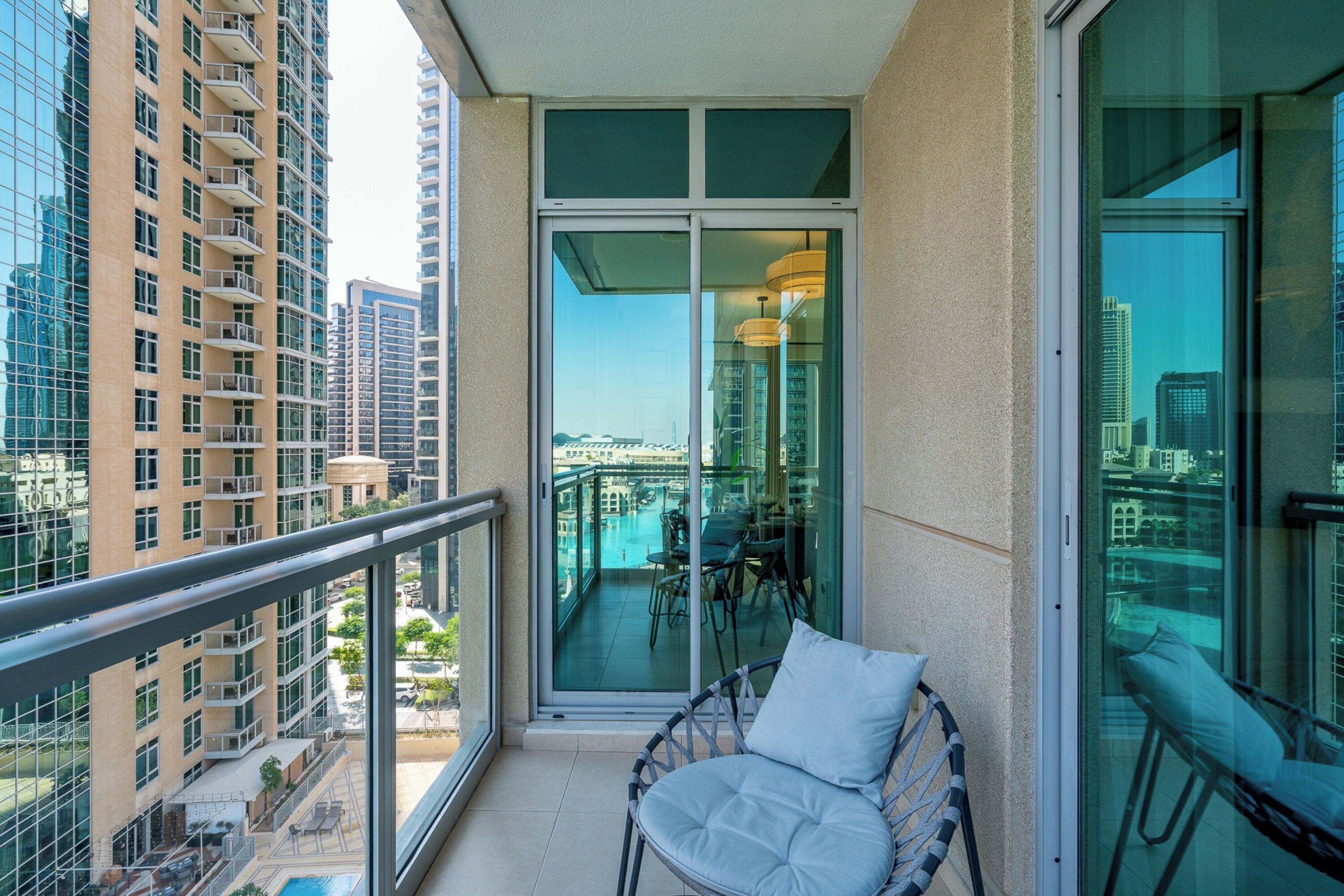 A balcony with a glass door, a chair, and a table with chairs.
