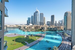 Una gran piscina curvada rodeada de edificios modernos, con vistas a un horizonte urbano al fondo.