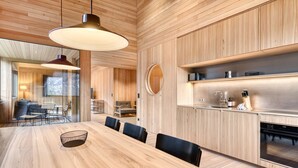 Una cocina moderna con armarios de madera, una mesa de comedor grande y sillas negras.
