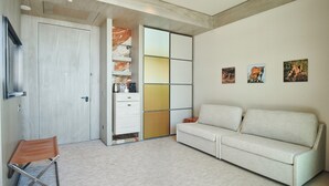 Una sala de estar moderna con un sofá, un sillón, un mueble con espacio de almacenamiento y obras de arte en la pared.