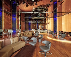 A spacious lobby with a bar area, leather seating, and a modern chandelier. - Voyage Kundu (Antalya)