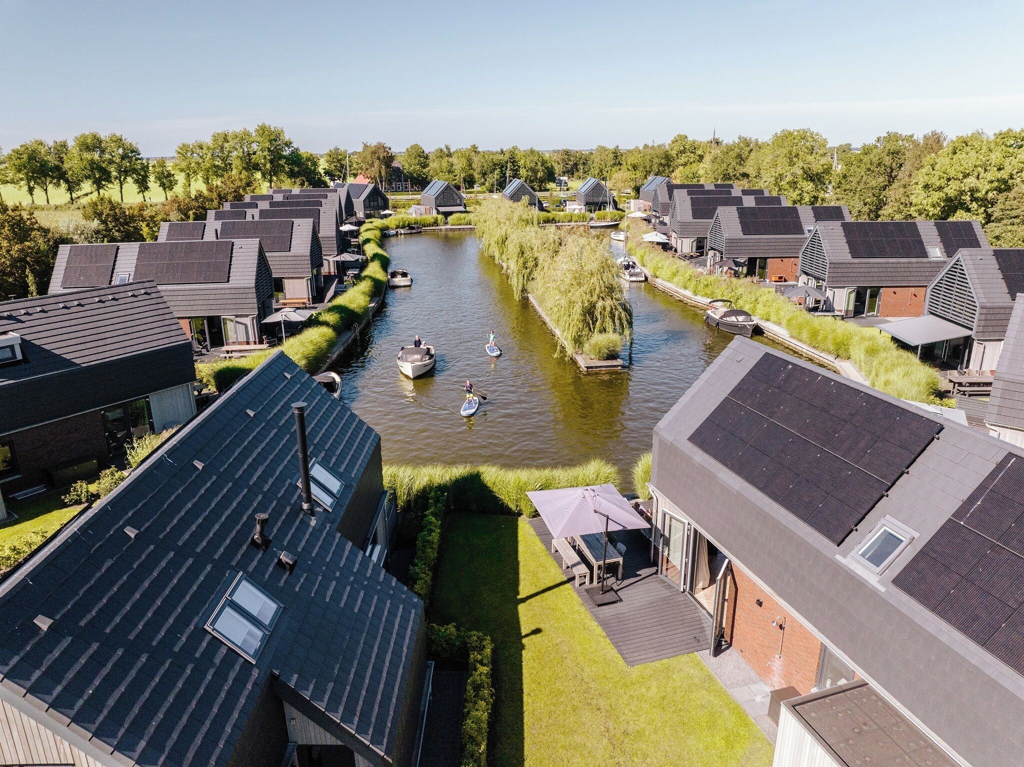 A residential area with modern houses, a canal, and a boat.