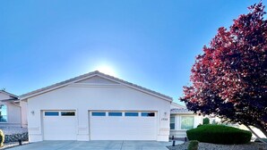 A single-story building with a white garage and a clear sky. - Large Prescott Home w/3-car Garage Central & Quiet (Prescott)