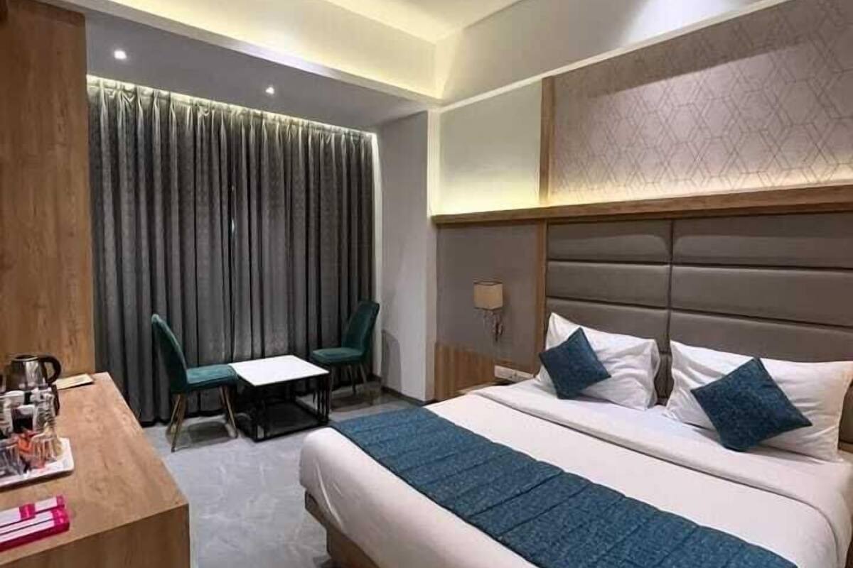 Una habitación de hotel moderna con una cama grande, un escritorio y una silla.