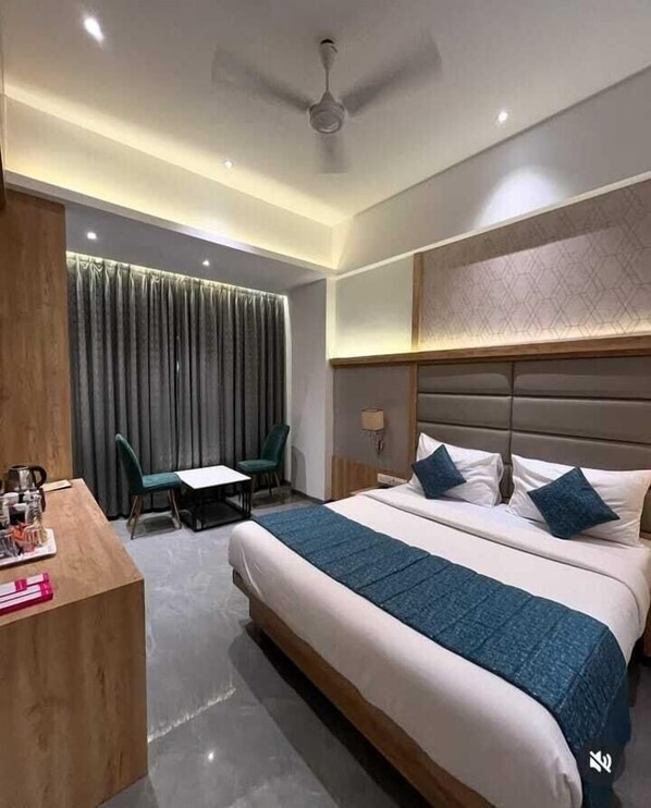 A modern hotel room with a large bed, a desk, and a chair.