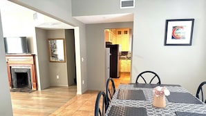 A dining area with a table set for four, a fireplace, and a kitchen visible in the background. - Minutes away from the beach and walking distance into town (St. Augustine)