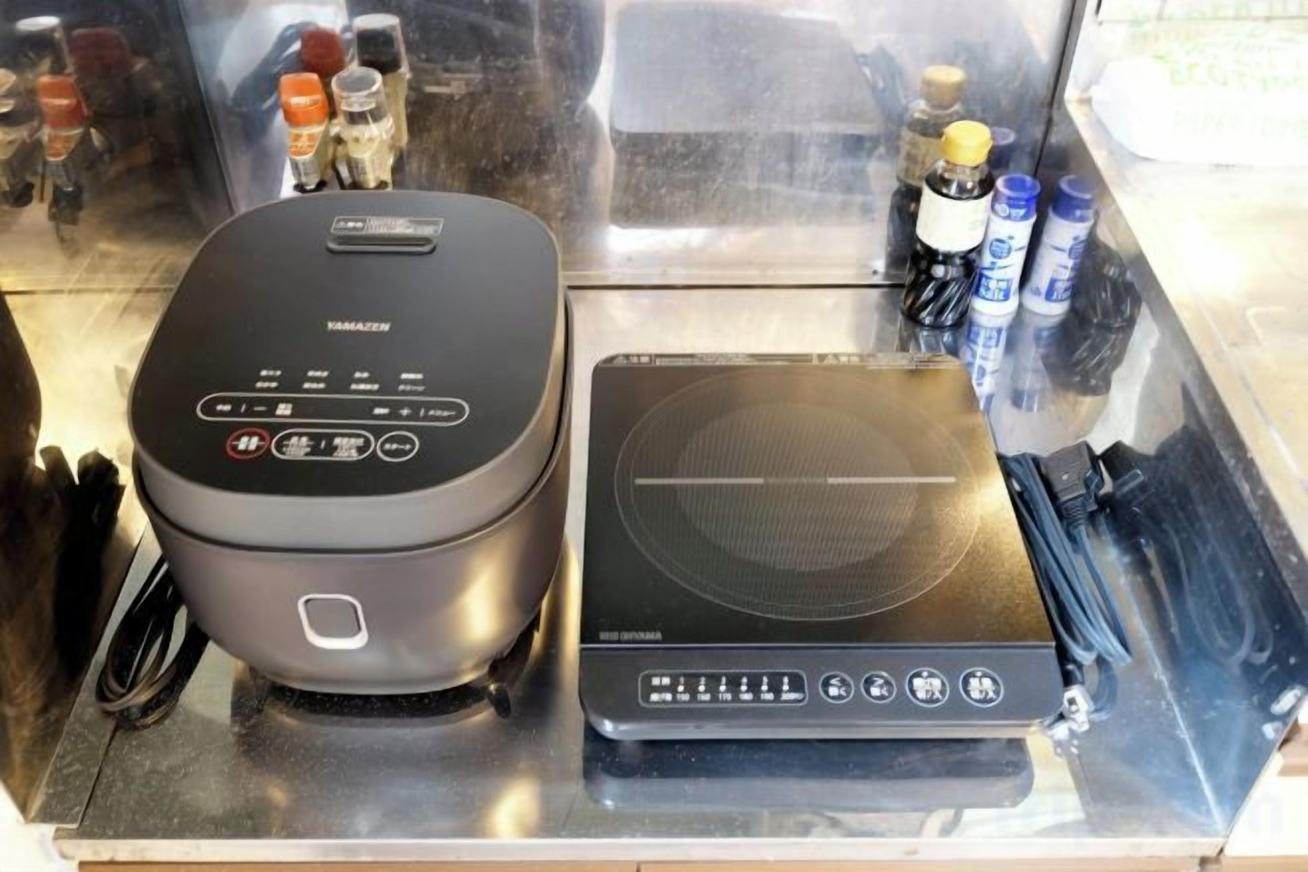 A kitchen area with a rice cooker and a microwave.