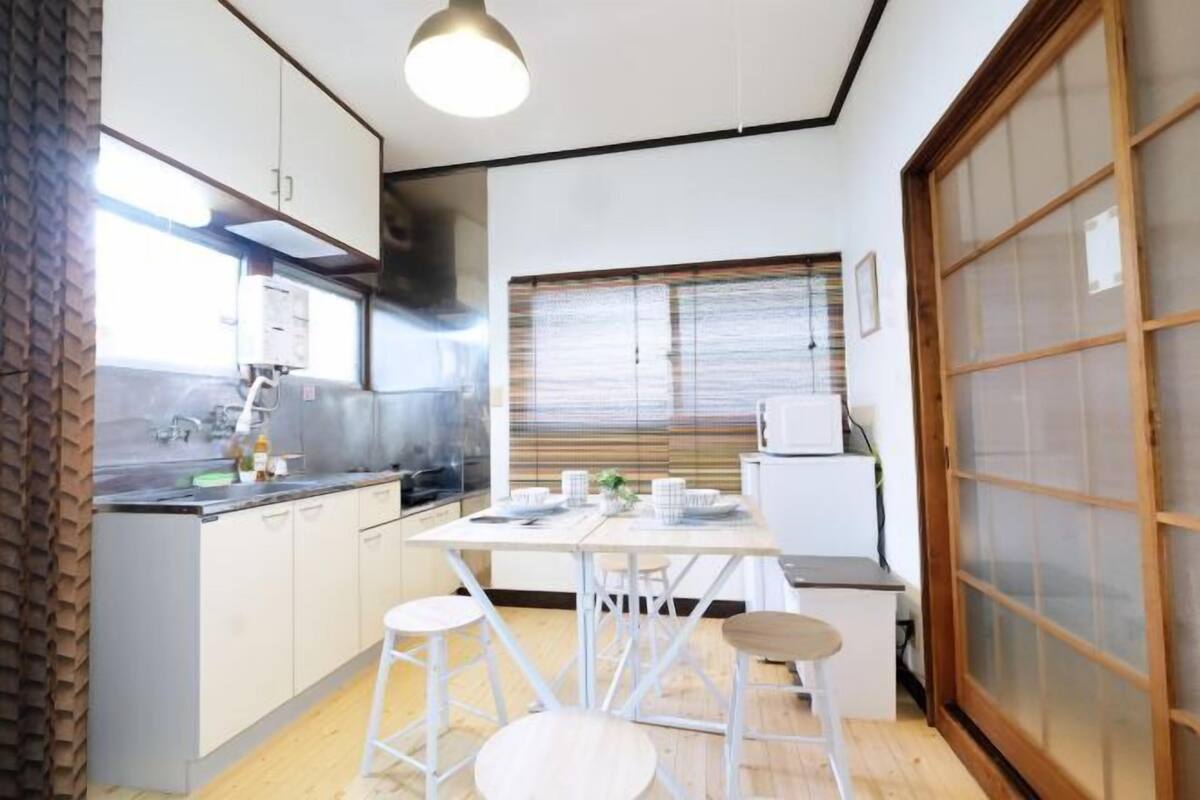 A compact kitchen with a dining area, a stove, and a refrigerator.