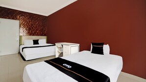 A hotel room with a large bed, a bedside table, and a wardrobe. - Hotel O Omah Bratan (Malang)
