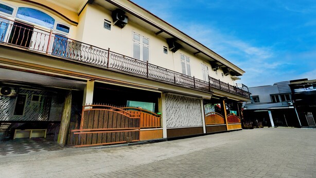 A building with a balcony, large windows, and a gated entrance. - Hotel O Omah Bratan (Malang)