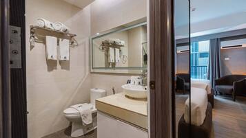 Un baño moderno con inodoro, lavamanos y perchero para toallas.