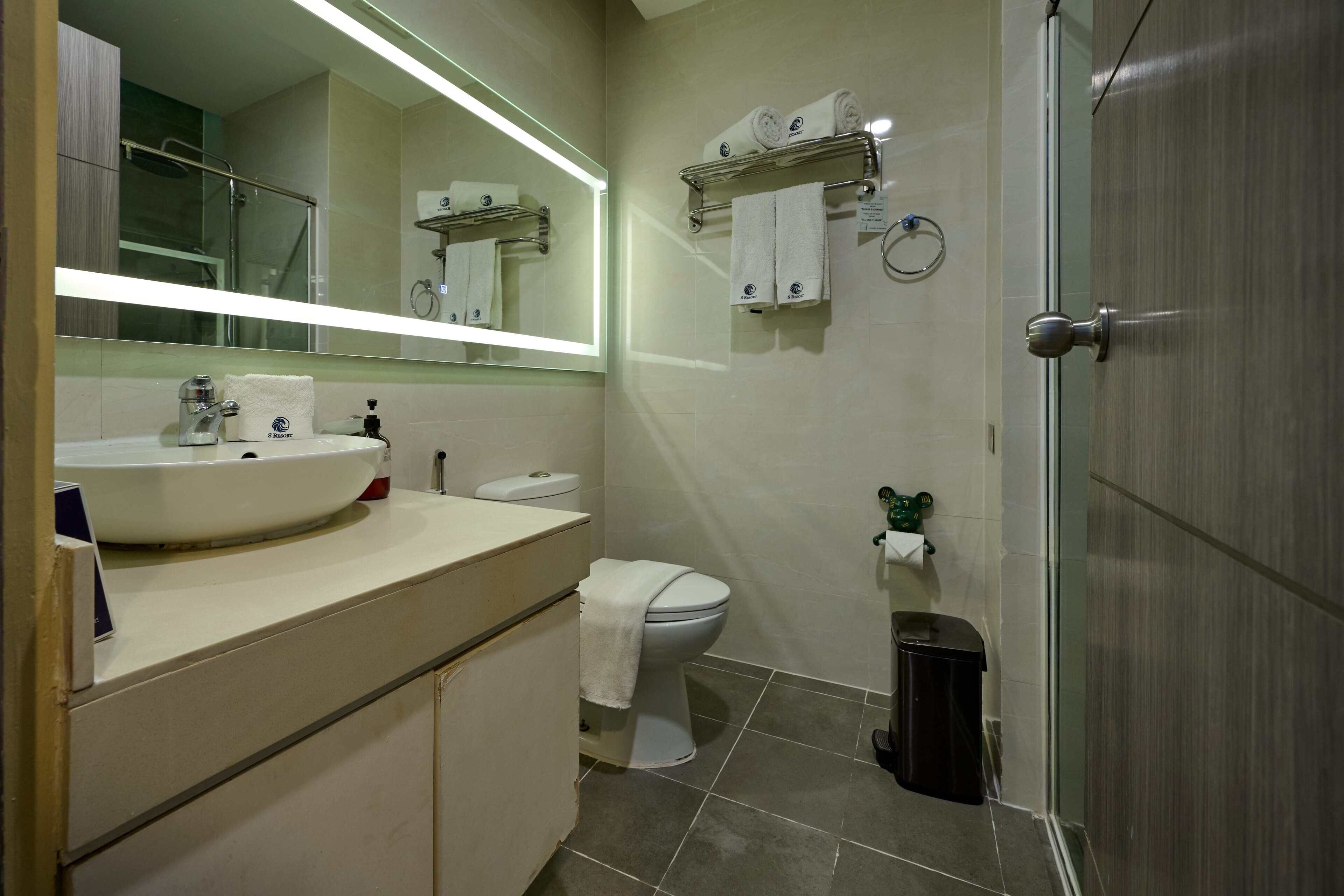 A bathroom with a sink, toilet, and shower area.