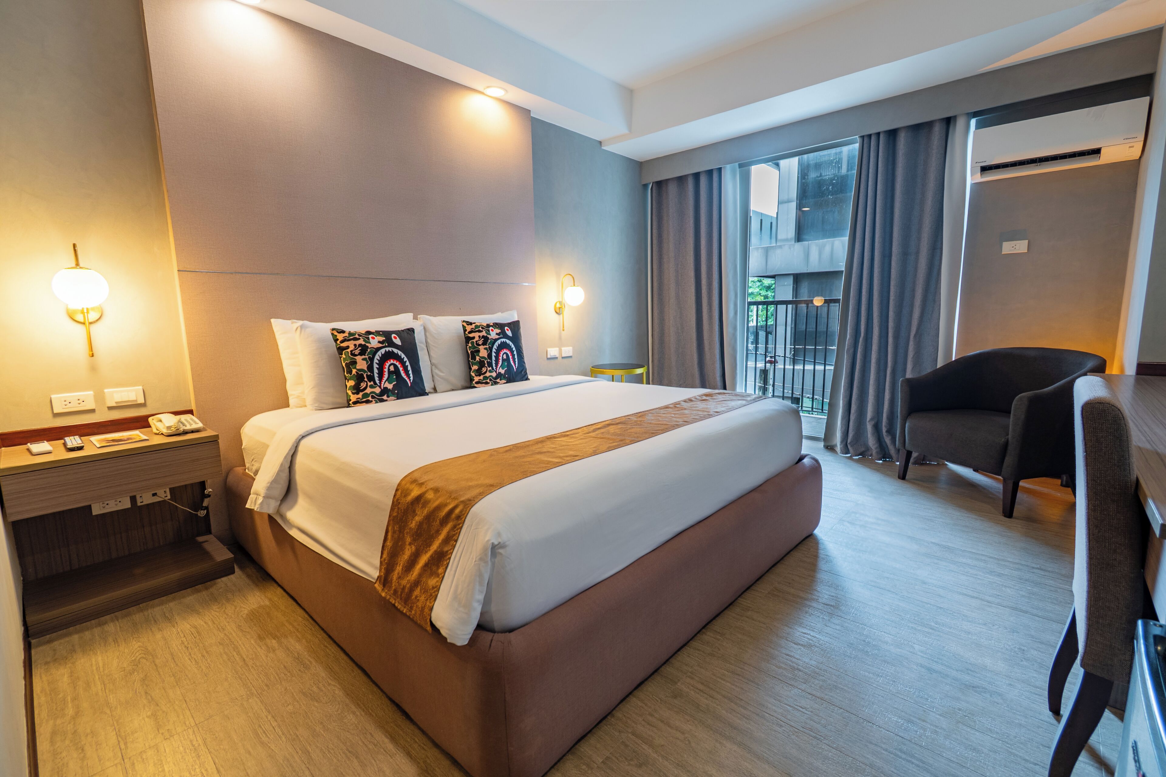A hotel room with a large bed, bedside tables, a desk, and a chair.