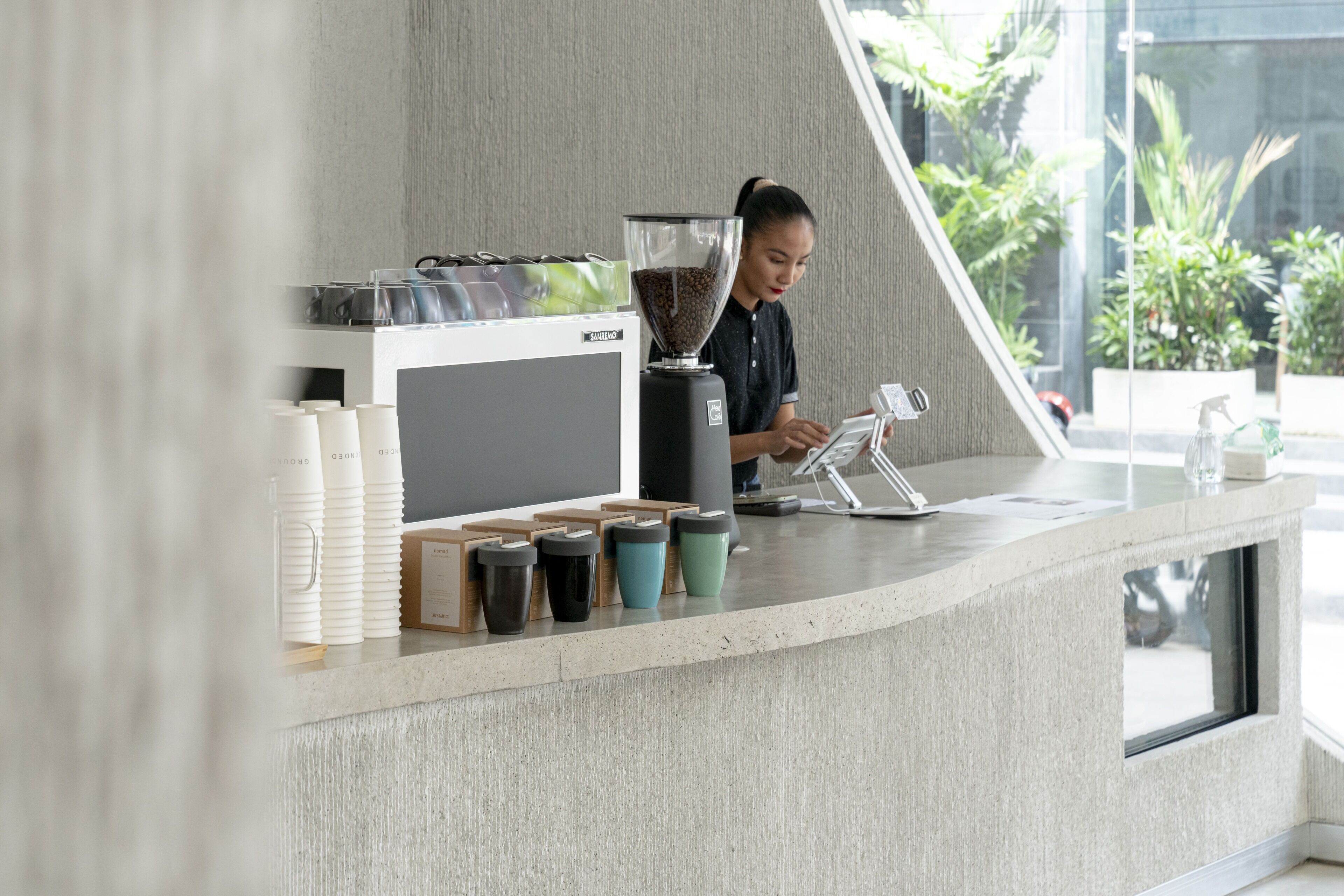 A coffee bar with a grinder, a digital scale, and various coffee cups.