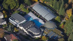 Vista aérea de una extensa propiedad con piscina, invernadero y varias construcciones.