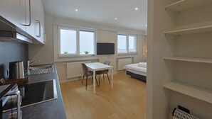 Una cocina moderna con comedor, televisor y cama.