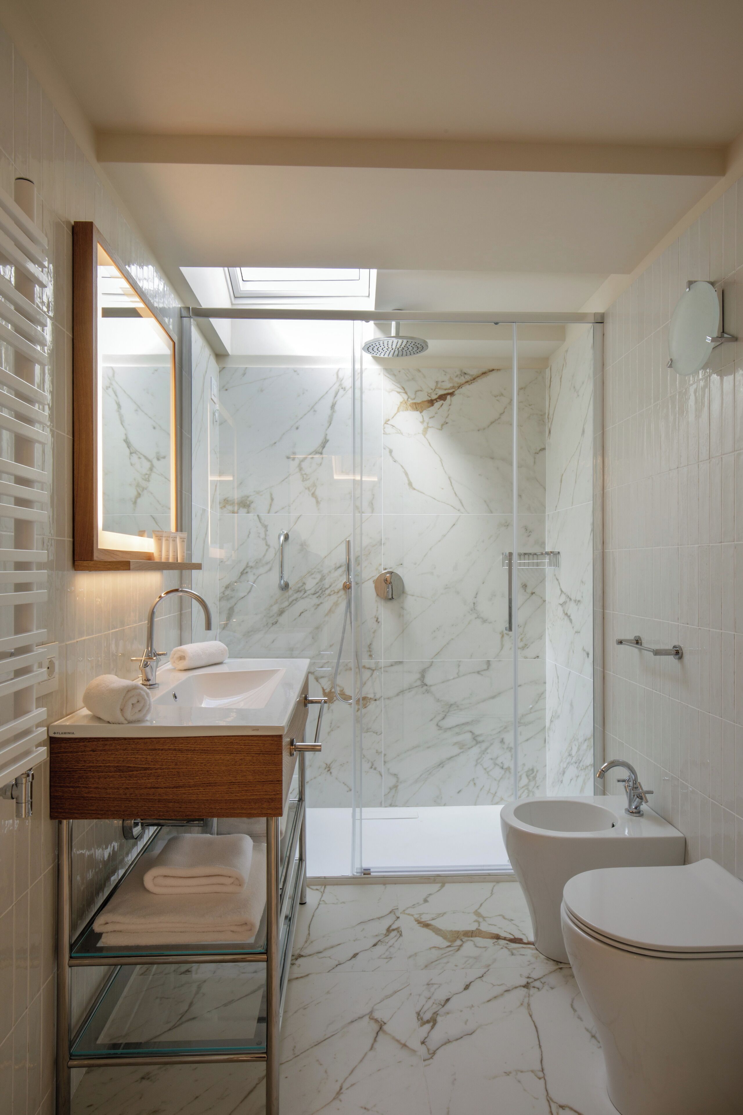 A modern bathroom with a glass-enclosed shower, a freestanding bathtub, and a vanity with a mirror.