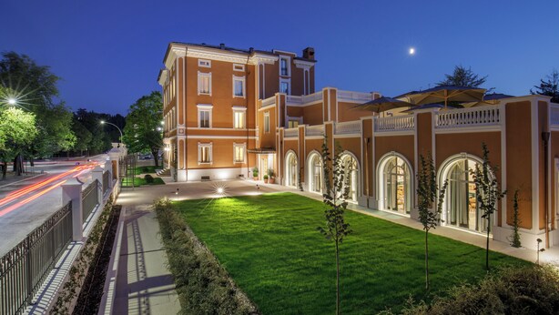 A large, multi-story building with a well-maintained lawn and a gated entrance. - Villa Miliani (Fabriano)