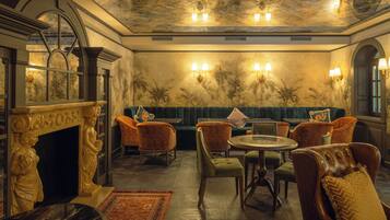 A luxurious room with a fireplace, seating area, and a dining table.