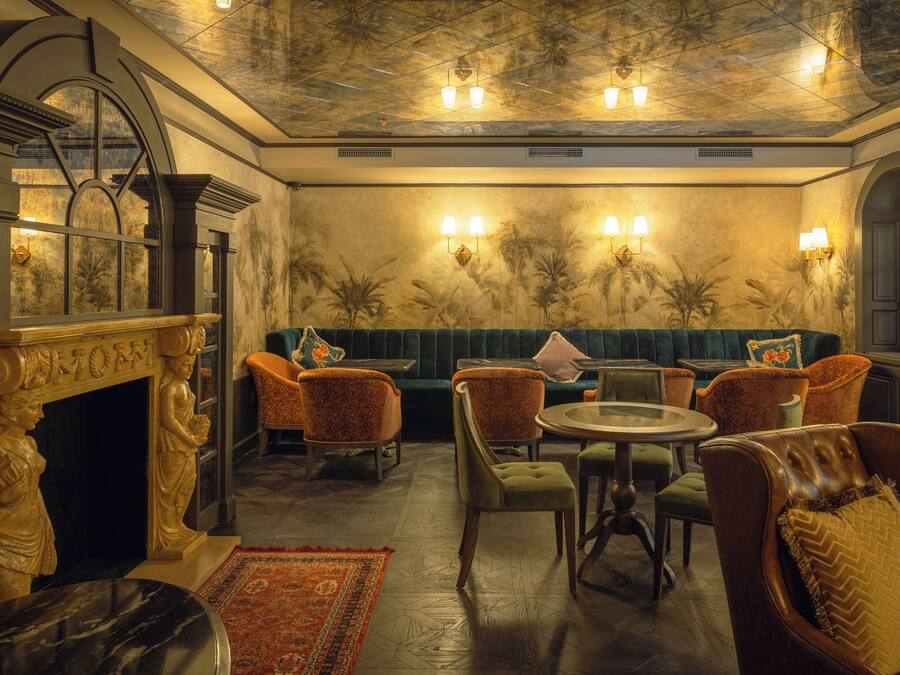 A luxurious room with a fireplace, seating area, and a dining table.