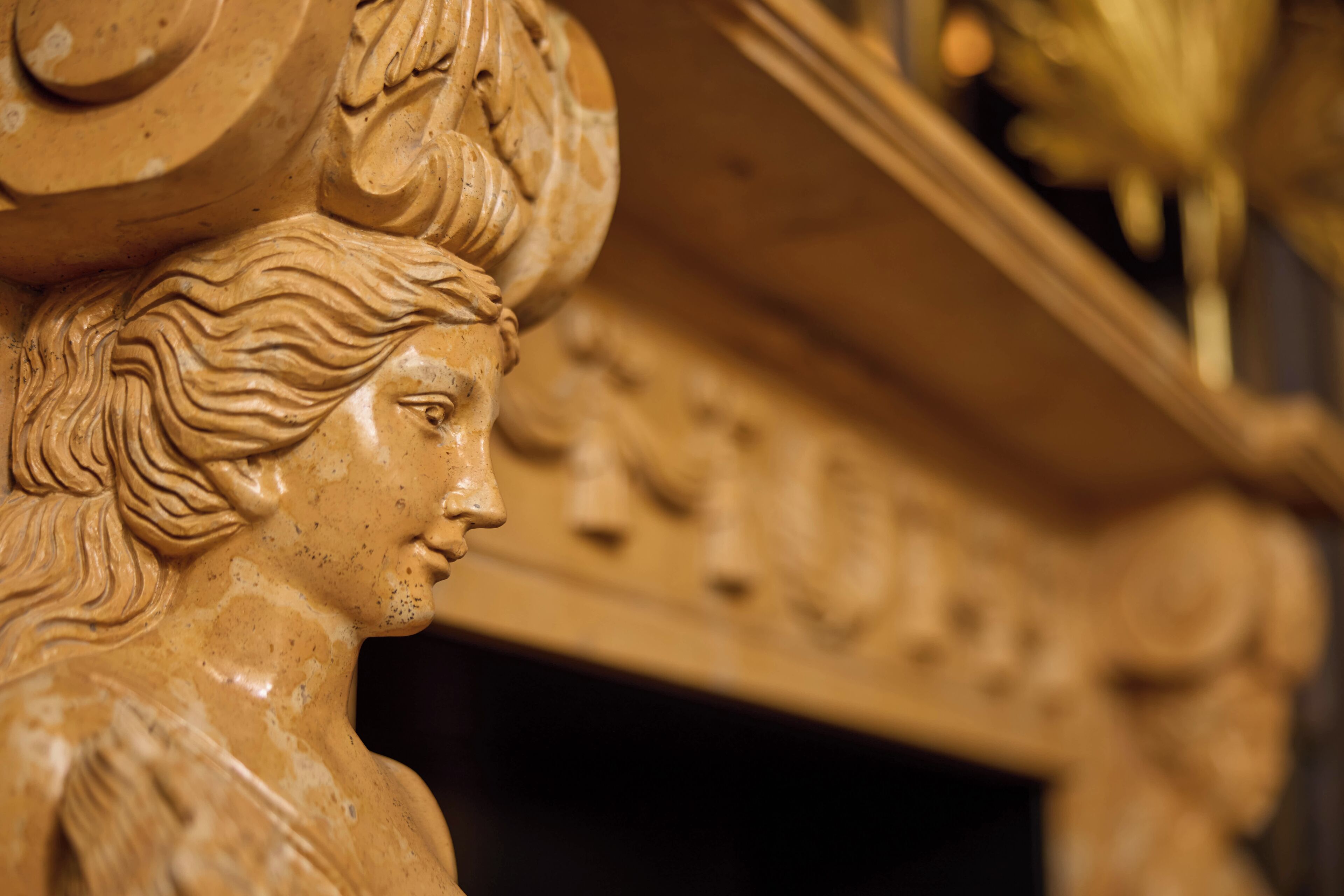 A detailed sculpture of a classical figure with intricate hair and facial features.