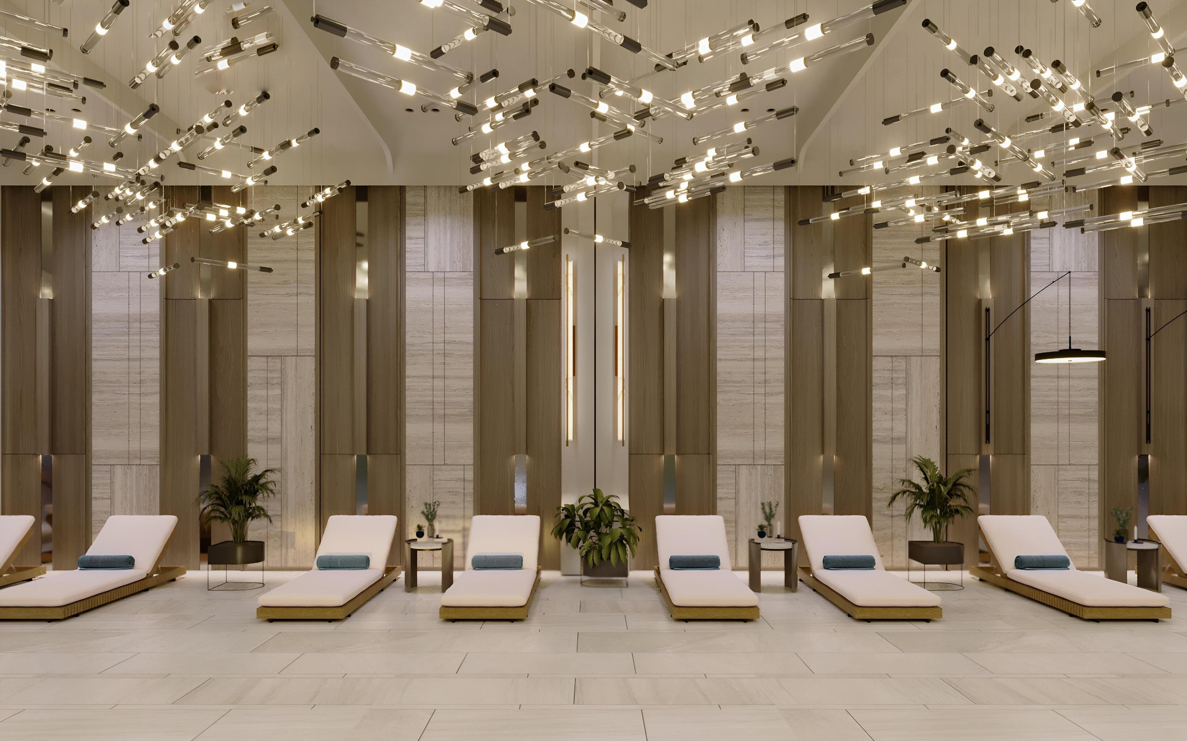 A modern spa area with multiple sun loungers, a ceiling with hanging lights, and wooden panel walls.