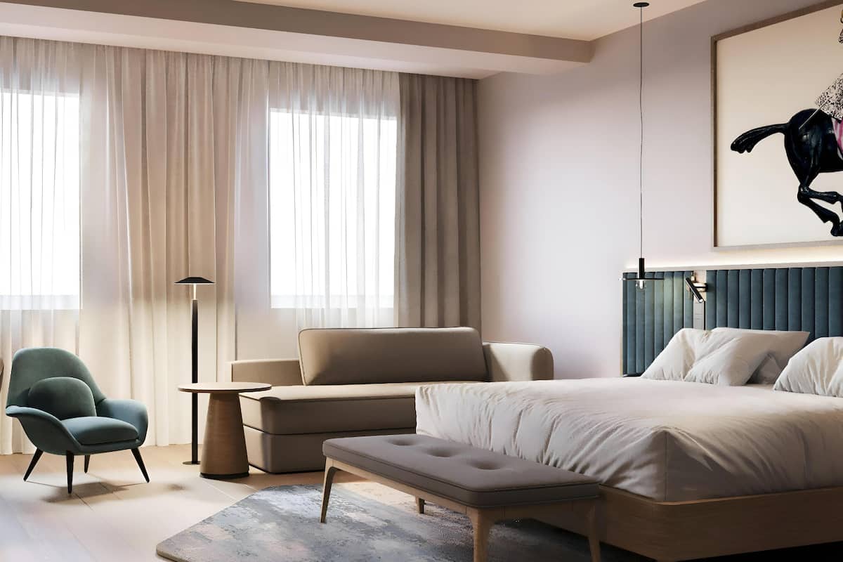 Et moderne soveværelse med en stor seng, en sofa, en lænestol og en gulvlampe.