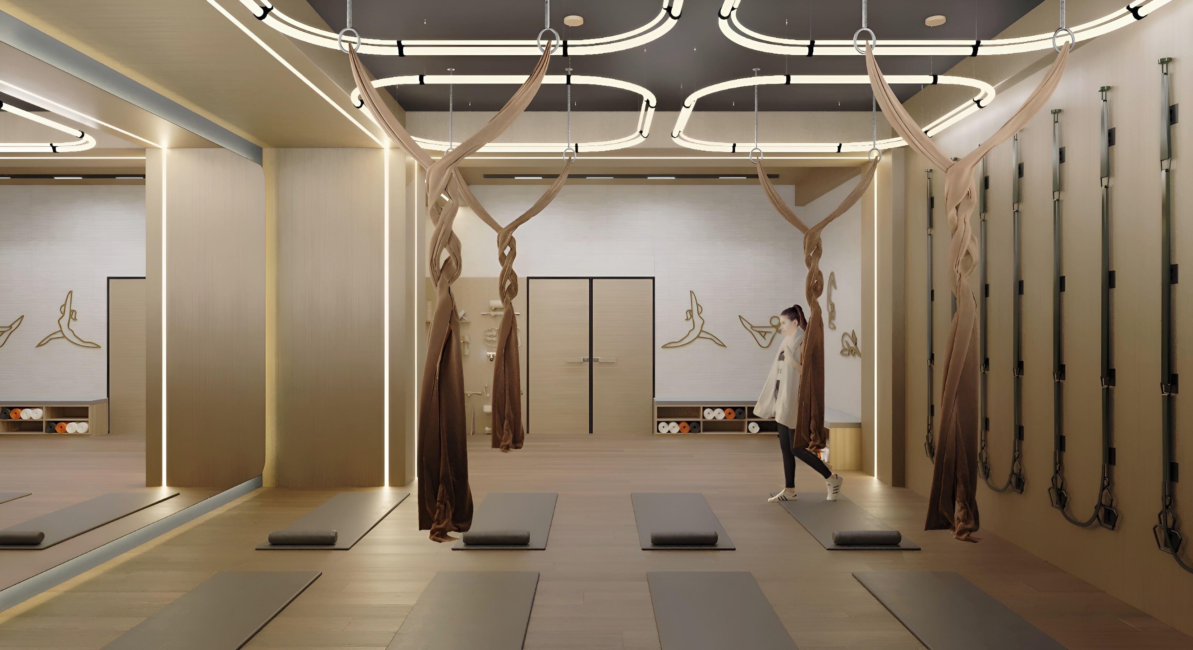 A yoga studio with suspended aerial silks, yoga mats, and a minimalist design.