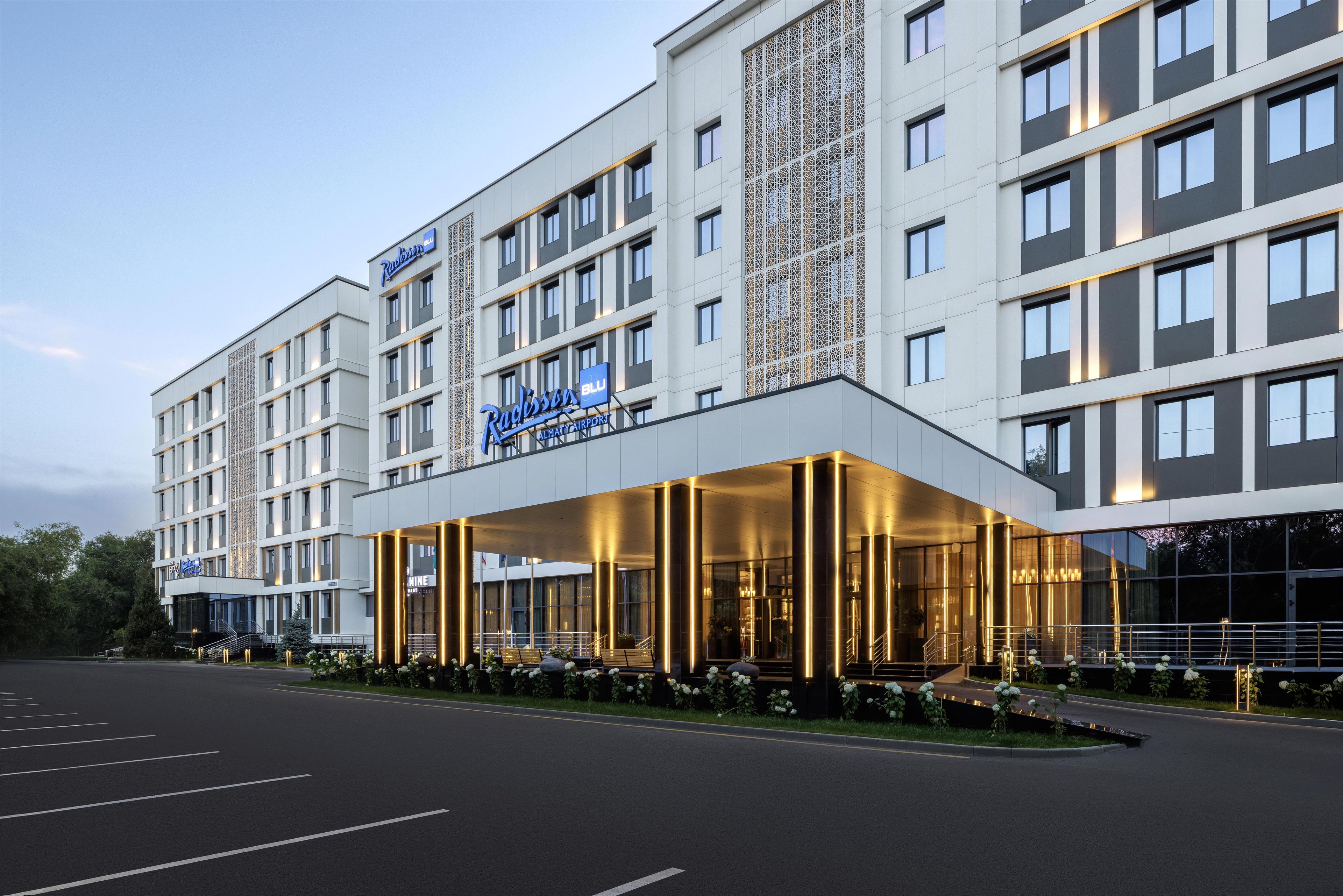 A Radisson Blu hotel with a modern facade, multiple balconies, and a well-lit entrance.