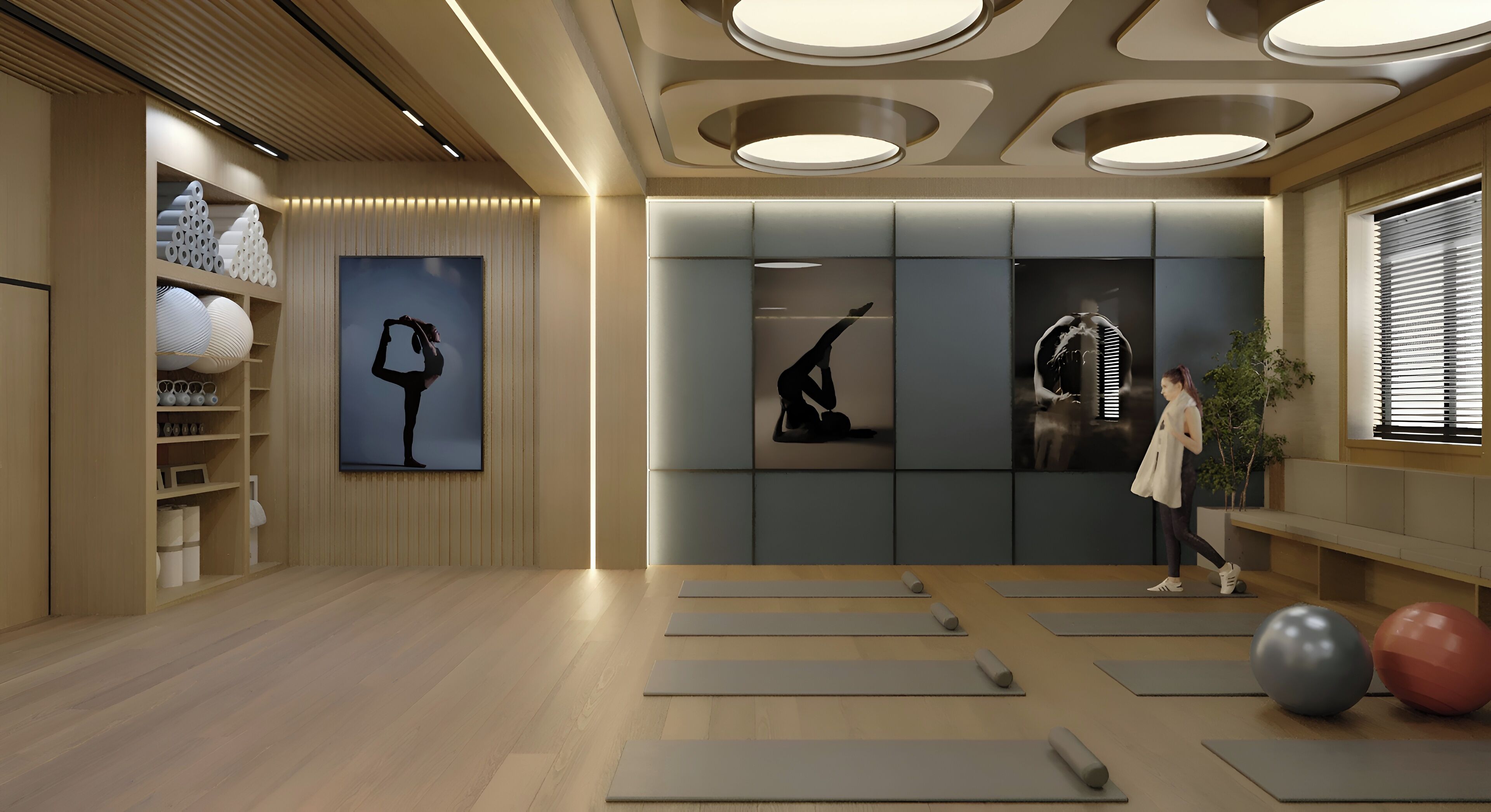 A yoga studio with mats, wall art, and a person practicing.