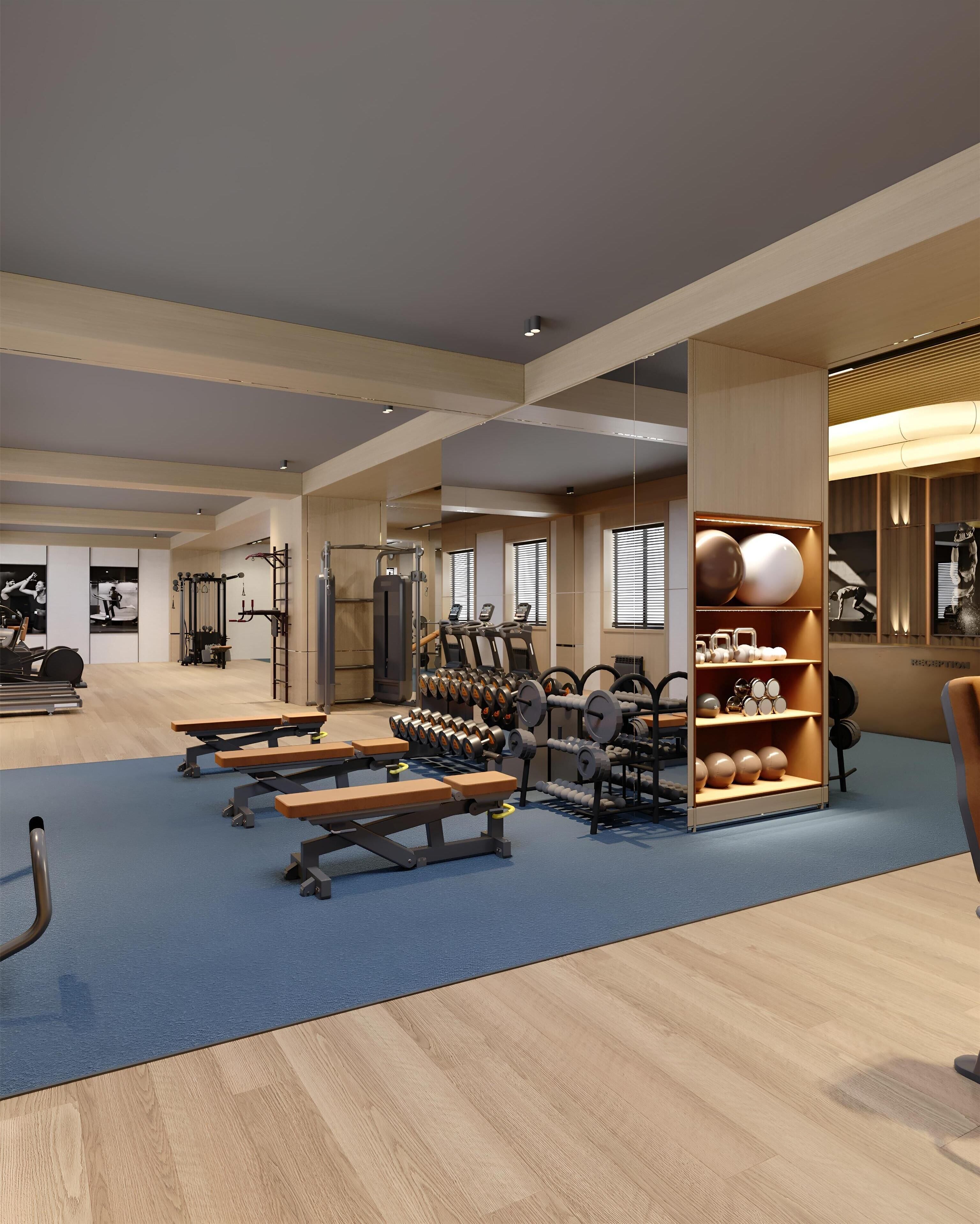Un gimnasio moderno con equipo de ejercicio, bancos y un soporte para pesas.