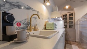 A modern kitchen with a marble backsplash, a built-in sink, and a microwave. - Design in Corso Francia 2 by Wonderful Italy (Turin)