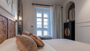 A bedroom with a large bed, a balcony with a view, and a decorative headboard. - Design in Corso Francia 2 by Wonderful Italy (Turin)