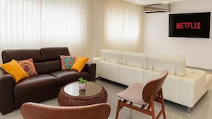Ein modernes Wohnzimmer mit einer braunen Ledersofa, einem weißen Sofa und einem runden Couchtisch.